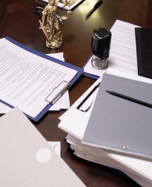 Group of objects and several stacks of juridical papers in clipboards and folders on workplace of lawyer